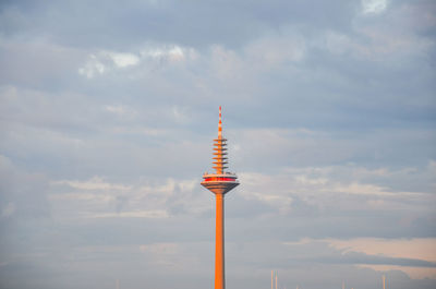 Communications tower in evening light against sky