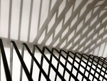 Close-up of shadow on railing against wall