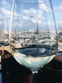 Close-up of beer glass on table against sky