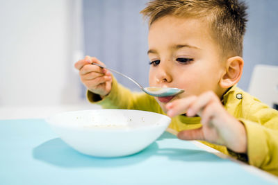 Close-up of boy eating soup at home