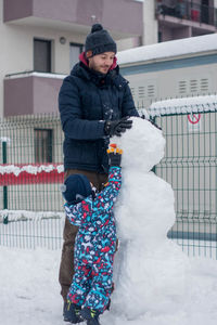 Son and dad making a snowman