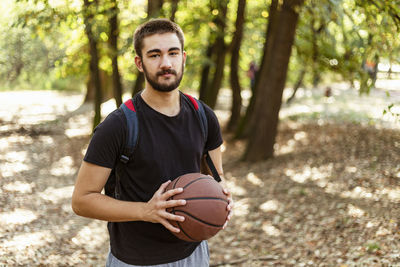 Portrait of beautiful trendy fashionable hispanic teenager male in basketball court