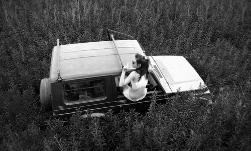 High angle view of young woman in 4x4 window in field