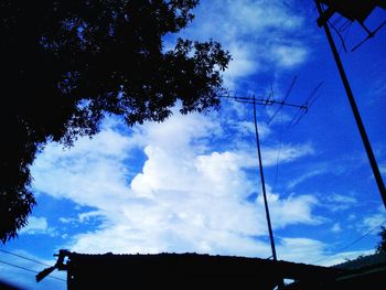 Low angle view of silhouette trees against blue sky