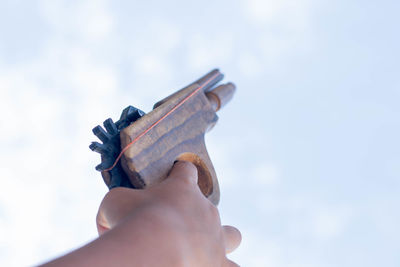 Close-up of person holding hands against sky