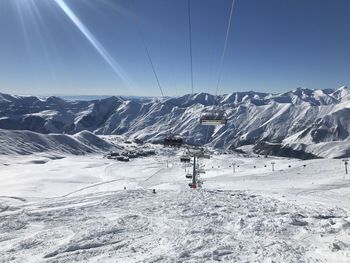 Ski lift over snowcapped mountains 