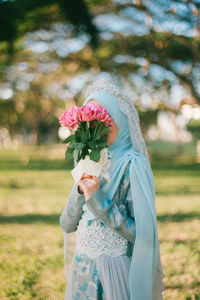 Young woman with flower petals on tree