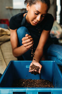 Woman pouring coffee beans in container