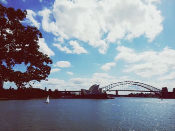 Bridge over river against cloudy sky