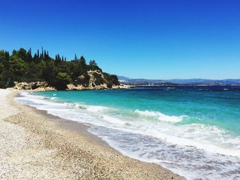 Scenic view of beach against clear blue sky