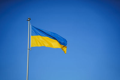 Yellow-blue flag of ukraine in the wind against the background of a cloudless sky