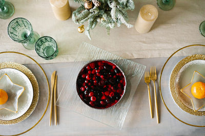 Served festive table for the christmas dinner on the background of a sparkling christmas tree. 