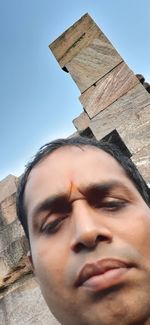 Low angle portrait of man against sky