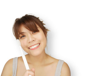 Portrait of a smiling young woman over white background