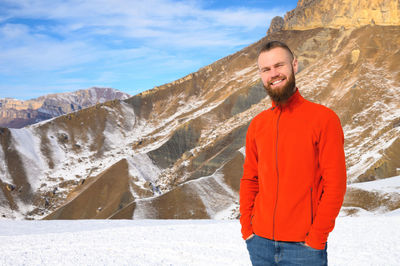 Young man standing on snow covered mountain