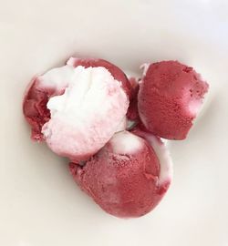 High angle view of pink fruits against white background