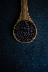 Organic black rice as a cooking ingredients on concrete background with copy space