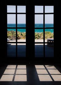 Trees and sea seen through window