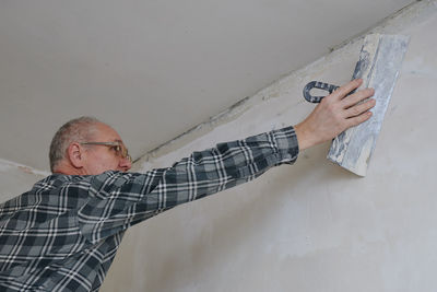 Portrait of young man standing against wall