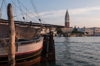 Conic tower of venice in the evening light with sailboat in the foreground