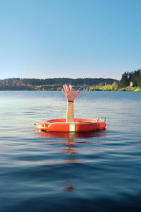 Woman standing on lake against clear sky