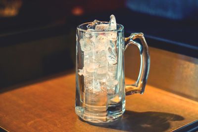 Close-up of ice cubes in drinking glass on table