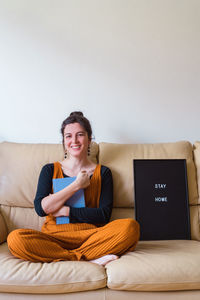 Portrait of smiling woman sitting on sofa