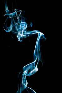 Close-up of blue burning over black background