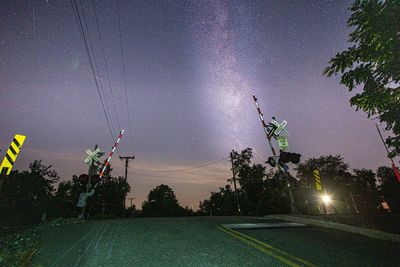 Low angle view of illuminated street lights against sky at night