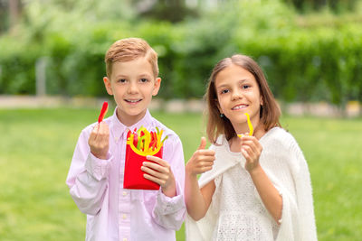 Portrait of a smiling boy holding a serious outdoors