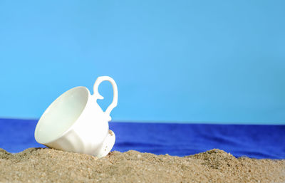 Close-up of white beach against blue sky