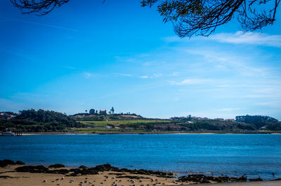 Calm blue sea with buildings in background