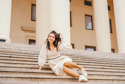 Portrait of young woman sitting on staircase