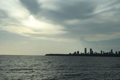 Scenic view of sea by buildings against sky