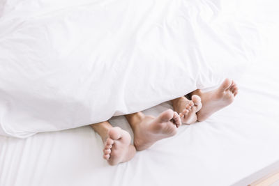 Low section of person sleeping on bed