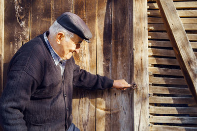 Side view of man standing on wooden floor