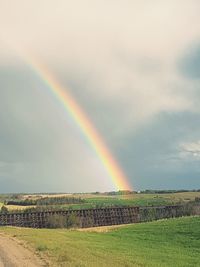 Rainbow over field against sky