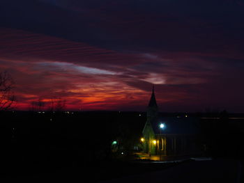 Silhouette city against sky at night