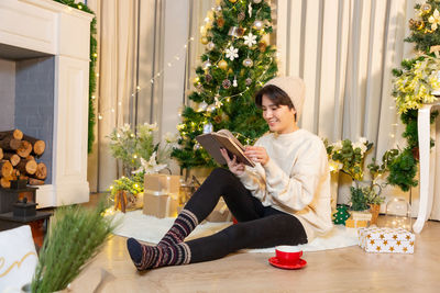 Portrait of young woman sitting on sofa at home