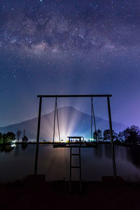 Swings and mountains under the stars of the milky way at night