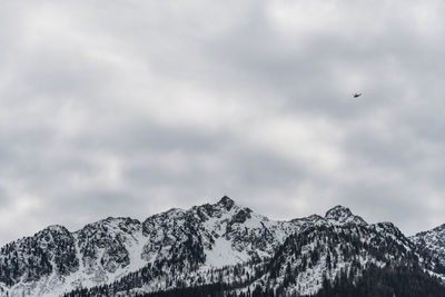 Small helicopter above snow-capped mountains peaks. the brenta dolomites. mountains panorama alps.