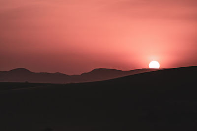 Scenic view of silhouette mountains against sky during sunset