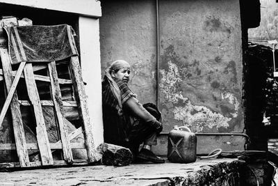 Portrait of man sitting in abandoned building