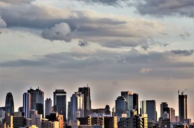 View of cityscape against cloudy sky