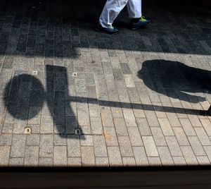 Low section of man with shadow on street