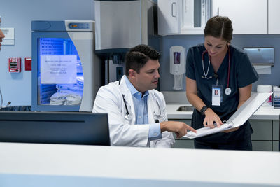 Doctor and nurse reviewing documents at hospital reception