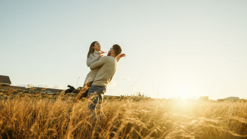 Boy and girl couple hug and walk together in the natural park