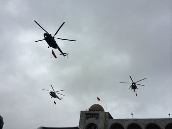Low angle view of helicopters flying in sky