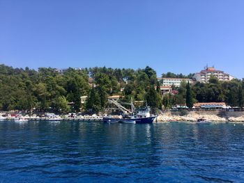 Sailboats in sea against clear blue sky