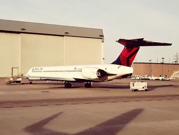 Airplane on airport runway against sky